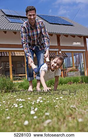 Stock Image - Father with daughter in front of Lehner energy house, Poing, Bavaria, Germany, Europe . Fotosearch