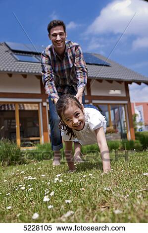 Stock Photography - Father with daughter in front of Lehner energy house, Poing, Bavaria, Germany, Europe . Fotosearch