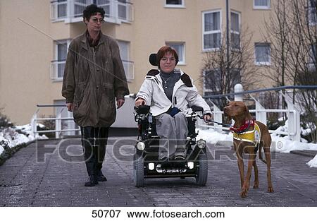 Stock Photo - Female caretaker with handicapped woman and dog on road . Fotosearch