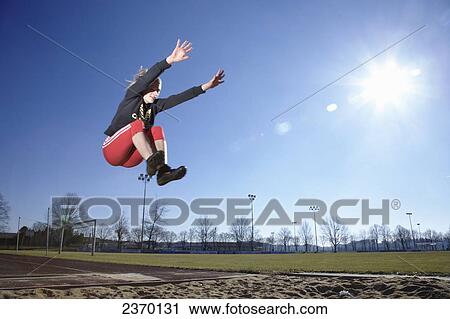 Female long jumper in mid-air View Large Photo Image Stock Image - Female long jumper in mid-air . Fotosearch