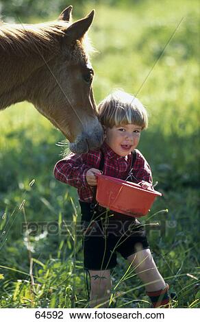 Foal and boy with bucket in field View Large Photo Image Stock Image - Foal and boy with bucket in field . Fotosearch