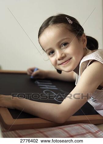 Stock Image - Girl writing on blackboard . Fotosearch