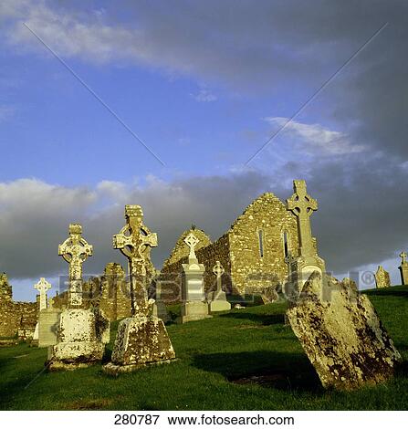 Stock Photo - Graves in cemetery near old ruins church, Clonmacnoise, Ireland . Fotosearch