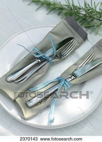 Stock Image - High angle view of forks and knives tied together with ribbon . Fotosearch