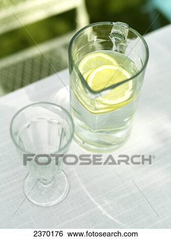 Stock Photograph - High angle view of glass and pitcher of lemonade . Fotosearch