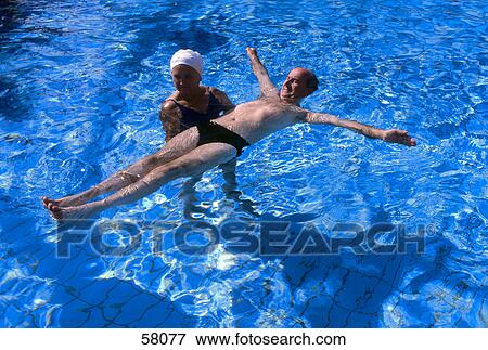 High angle view of woman teaching man to swim in swimming pool View Large Photo Image Stock Photo - High angle view of woman teaching man to swim in swimming pool . Fotosearch