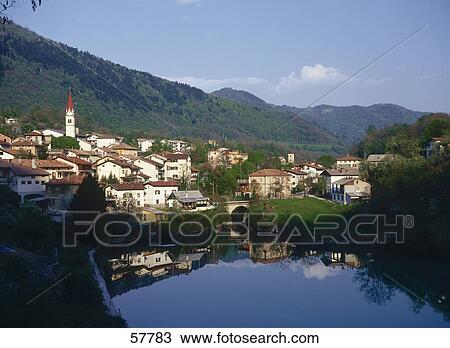 Stock Image - Houses in a town and sky reflected in the river water, Slovenia . Fotosearch