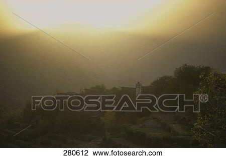 Stock Image - Houses on hill at dusk, Morocco . Fotosearch