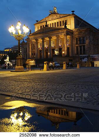 Lamppost lit up in front of building at dusk View Large Photo Image Stock Photo - Lamppost lit up in front of building at dusk . Fotosearch