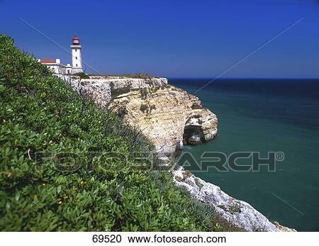 Stock Image - Lighthouse on a cliff at the coast, Carvoeiro, Algarve, Portugal . Fotosearch