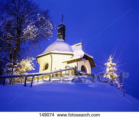 Picture - Low angle view of chapel lit up at dusk, Bayersoien Chapel, Upper Bavaria, Bavaria, Germany . Fotosearch