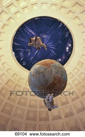 Picture - Low angle view of cosmonaut figurine with globe inside space museum . Fotosearch