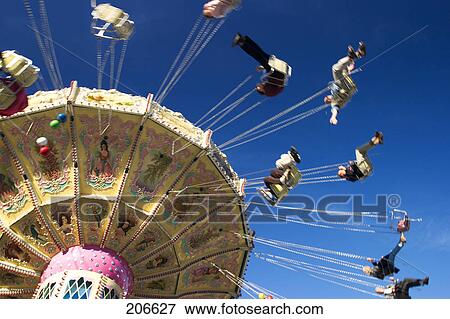Low angle view of people riding on chairoplane, Munich, Bavaria, Germany View Large Photo Image Stock Photo - Low angle view of people riding on chairoplane, Munich, Bavaria, Germany . Fotosearch
