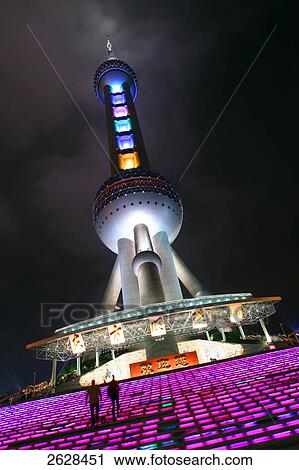 Stock Image - Low angle view of tv tower lit up at night, Oriental Pearl Tower, Pudong, Shanghai, China . Fotosearch