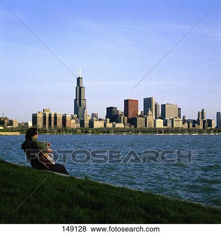 Stock Photo - Man playing guitar at coast, Chicago, Illinois, USA . Fotosearch