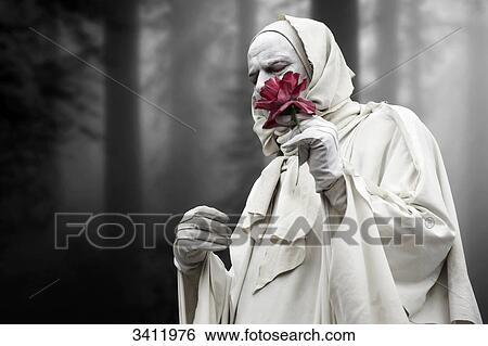 Man wrapped in white cloth holding flower in his hand View Large Photo Image Stock Photograph - Man wrapped in white cloth holding flower in his hand . Fotosearch