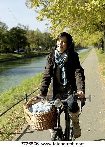Mature woman cycling along river View Large Photo Image Stock Photograph - Mature woman cycling along river . Fotosearch