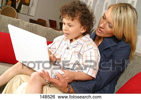Mid adult woman and her son using laptop View Large Photo Image Stock Photograph - Mid adult woman and her son using laptop . Fotosearch