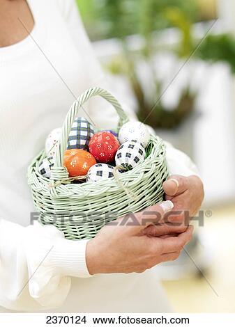 Mid section view of woman carrying basket of easter eggs View Large Photo Image Picture - Mid section view of woman carrying basket of easter eggs . Fotosearch