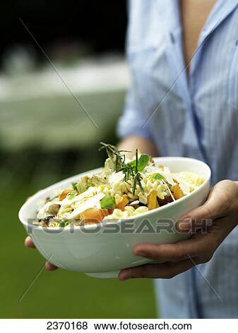 Mid section view of woman holding bowl of pasta salad View Large Photo Image Stock Photo - Mid section view of woman holding bowl of pasta salad . Fotosearch