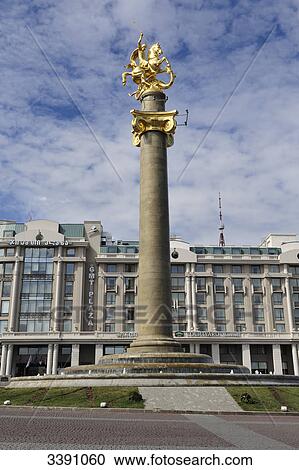 Stock Image - Monument of St. George on Tavisupleba Square, Hotel in the background, Tbilisi, Georgia . Fotosearch