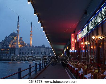 Stock Photo - Mosque lit up at dusk, Galata Bridge, New Mosque, Istanbul, Turkey . Fotosearch