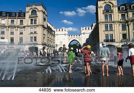 People enjoying near fountain at town square, Karlsplatz, Munich, Bavaria, Germany View Large Photo Image Stock Photography - People enjoying near fountain at town square, Karlsplatz, Munich, Bavaria, Germany . Fotosearch
