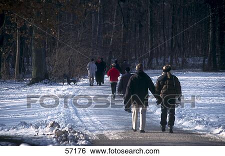 Stock Photograph - People walking on snowy path in park . Fotosearch