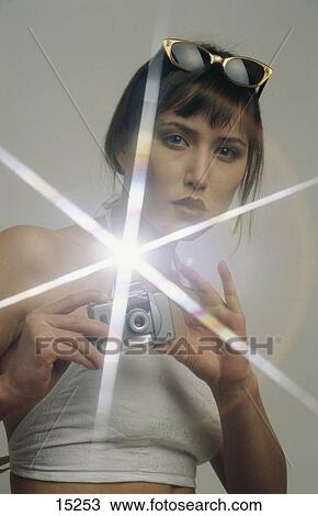 Stock Image - Portrait of a young woman taking a photograph . Fotosearch