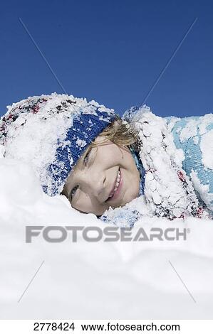 Portrait of boy lying on snow and smiling View Large Photo Image Picture - Portrait of boy lying on snow and smiling . Fotosearch