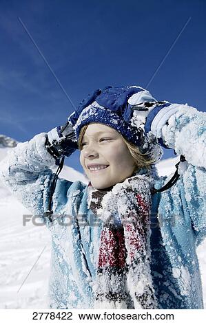 Stock Image - Portrait of boy smiling on snowcovered landscape . Fotosearch