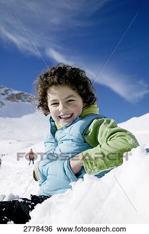Stock Photograph - Portrait of boy smiling on snowcovered landscape . Fotosearch