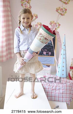 Portrait of girl holding cardboard cone and smiling on table View Large Photo Image Stock Photography - Portrait of girl holding cardboard cone and smiling on table . Fotosearch
