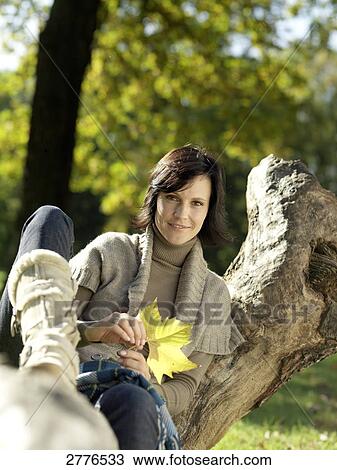 Portrait of mature woman sitting on fallen tree and smiling View Large Photo Image Stock Image - Portrait of mature woman sitting on fallen tree and smiling . Fotosearch