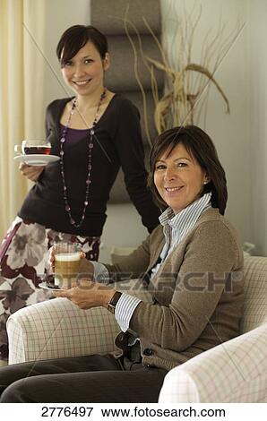 Portrait of woman and her daughter holding cups of coffee View Large Photo Image Stock Photo - Portrait of woman and her daughter holding cups of coffee . Fotosearch