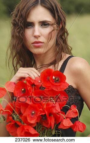 Portrait of young woman holding bouquet of flowers View Large Photo Image Stock Photograph - Portrait of young woman holding bouquet of flowers . Fotosearch