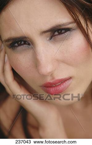 Stock Image - Portrait of young woman looking sad . Fotosearch