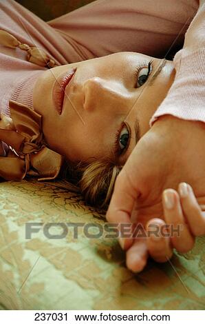 Portrait of young woman lying on bed View Large Photo Image Stock Image - Portrait of young woman lying on bed . Fotosearch