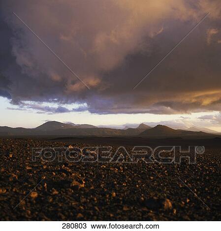 Stock Image - Purple dusky sky over arid landscape . Fotosearch