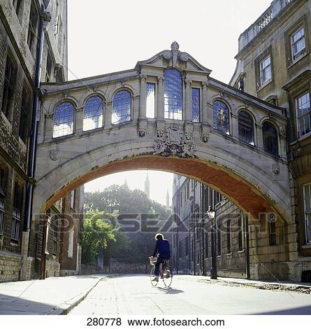 Stock Photo - Rear view of cyclist in alley . Fotosearch