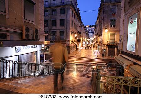Stock Image - Rear view of man walking downstairs, Chiado, Rua Aurea, Rua Santa Justa, Baxia, Lisbon, Portugal . Fotosearch