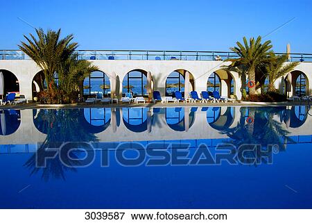Stock Photo - Reflection of arcades and palms on water surface of a swimming pool, Djerba, Tunisia . Fotosearch