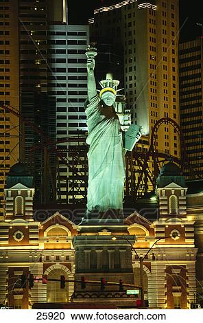 Stock Image - Replica Statue Of Liberty lit up in front of buildings, Las Vegas, Clark County, Nevada, USA . Fotosearch