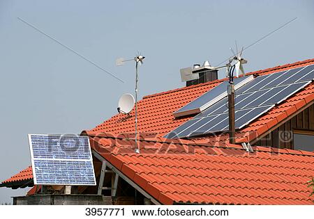 Stock Image - Roof with solar modules and wind charger . Fotosearch