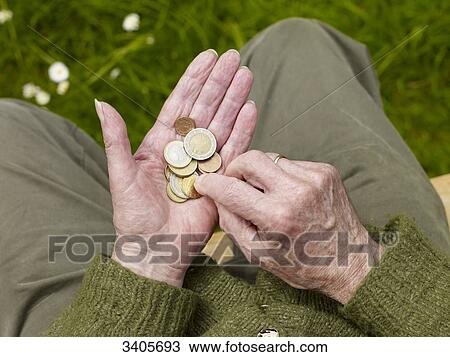 Stock Image - Senior man counting money in his hand, close-up . Fotosearch