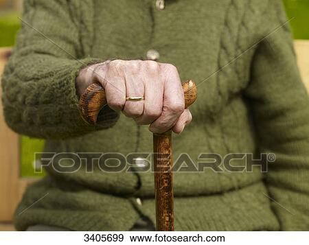 Stock Photo - Senior man holding hand on cane, close-up . Fotosearch