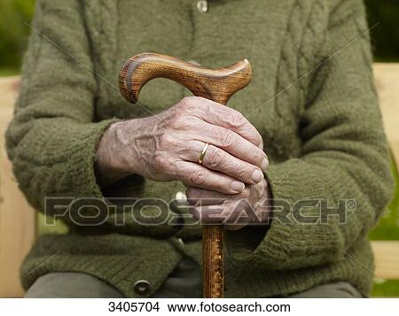 Senior man holding hands on cane, close-up View Large Photo Image Picture - Senior man holding hands on cane, close-up . Fotosearch