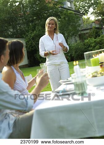 Side profile of couple looking at woman holding water bottle View Large Photo Image Stock Photo - Side profile of couple looking at woman holding water bottle . Fotosearch