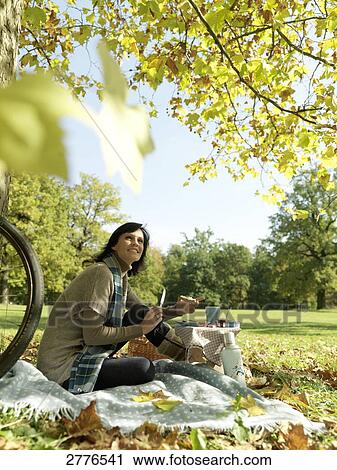 Side profile of mature woman holding slice of bread and smiling in park View Large Photo Image Stock Image - Side profile of mature woman holding slice of bread and smiling in park . Fotosearch