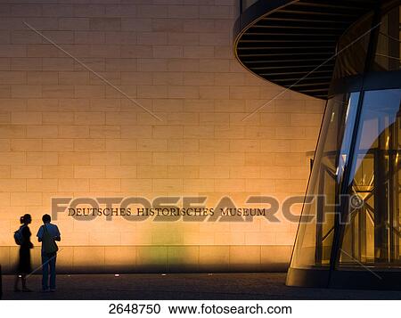 Stock Image - Silhouette of two people standing in front of museum, Berlin, Germany . Fotosearch
